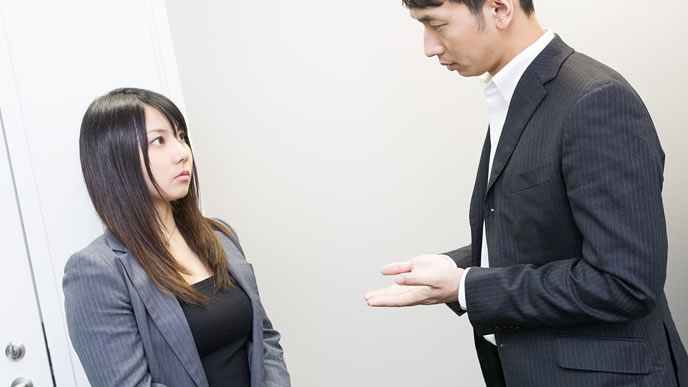 同僚と話し込む男性