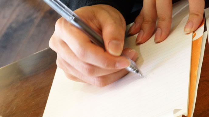 ボールえペンで書類をかく手