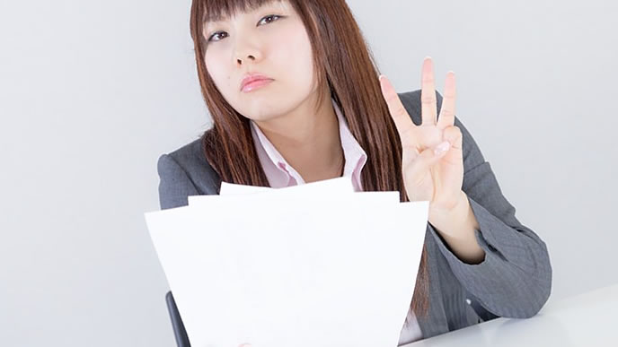書類を持ってカメラ目線の女性