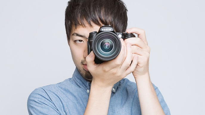 カメラで撮影中の男性