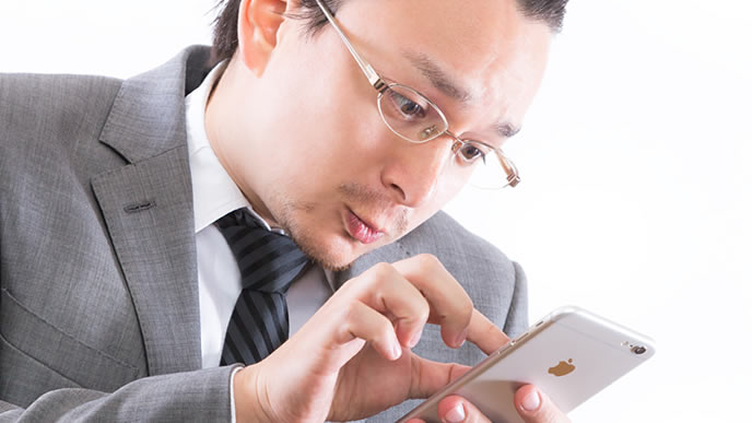スマホでメモをとる中年男性