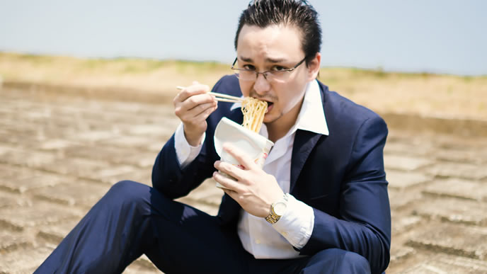 外で食事するサラリーマン