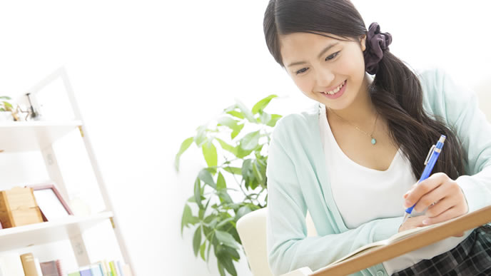 履歴書に資格を書き込んでいる女性