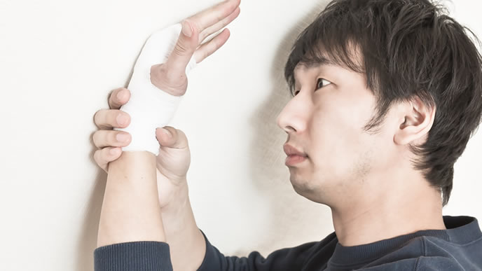 腕を怪我して悶絶している男性
