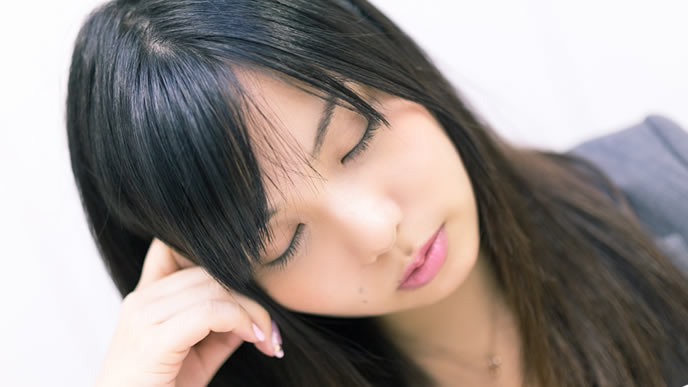 悩んでいるようで寝ている女性