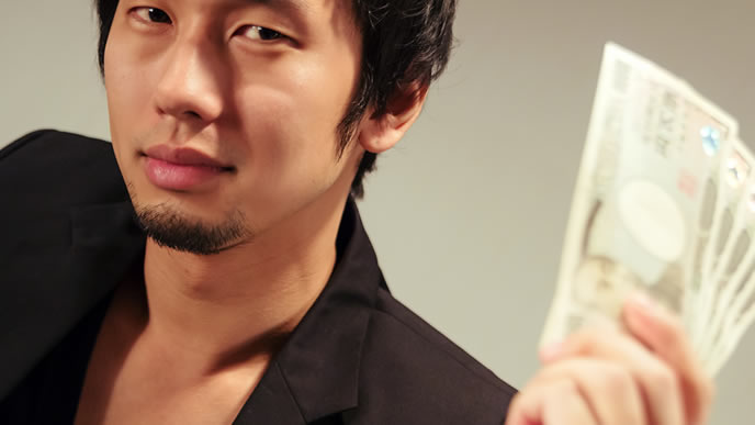 札束を見せつけドヤ顔の男性