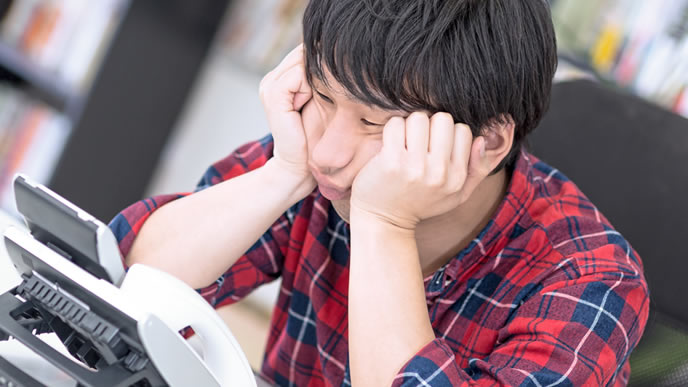 電話が来るのを待ちわびる男性