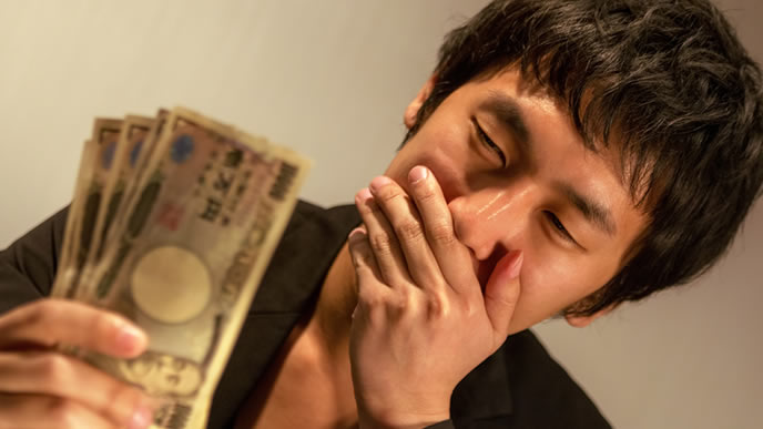 お金を手にして微笑んでいる男性
