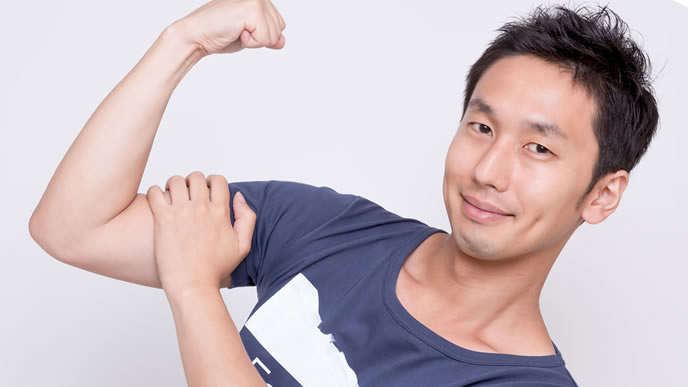力こぶを見せ付ける自信ありげな男性