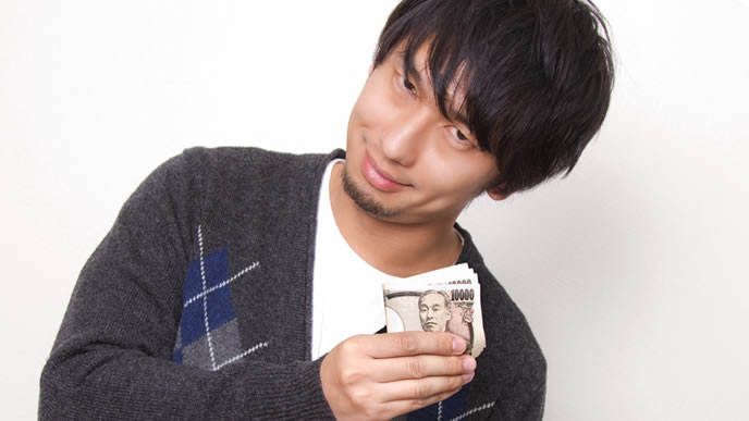 お金を持ってニヤリとする男性