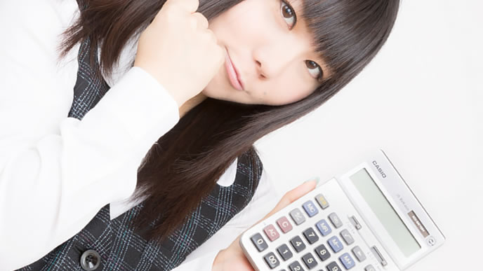 電卓で給料の計算をする女性