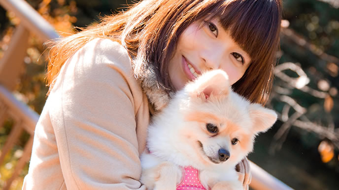 ポメを抱きしめる女性