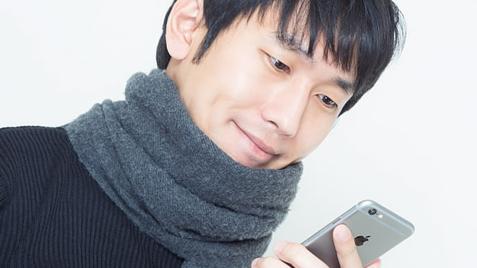 スマートフォンで時間を計測する男性