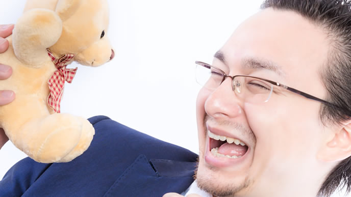 ぬいぐるみと戯れる男性