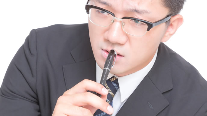 真剣な表情でネクタイを選んでいる男性