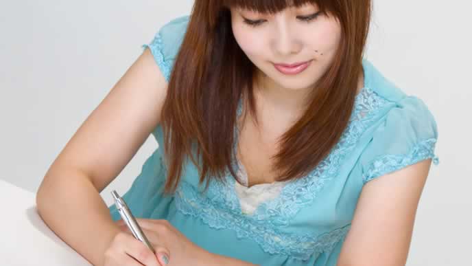 就職する為に職務経歴書を書いている女性