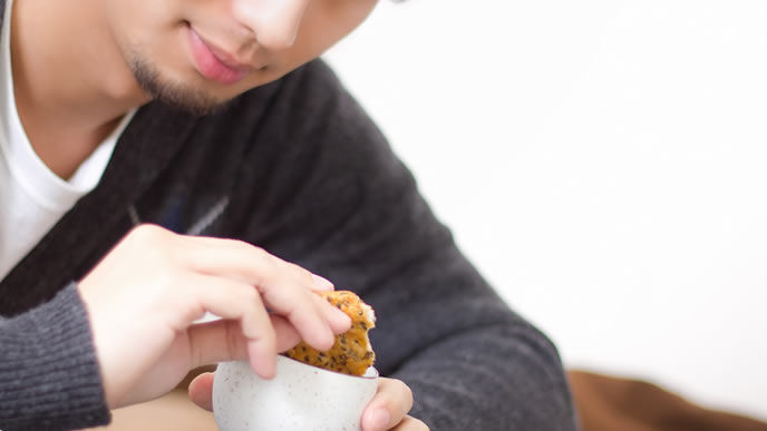 一人でせんべいをお茶に漬せられるようになった男性