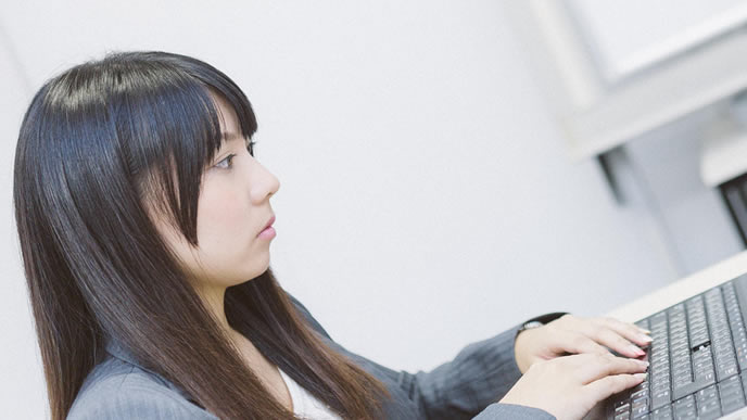 書類を片付けている女性