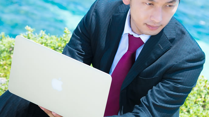 海で求人サイトを見る男性