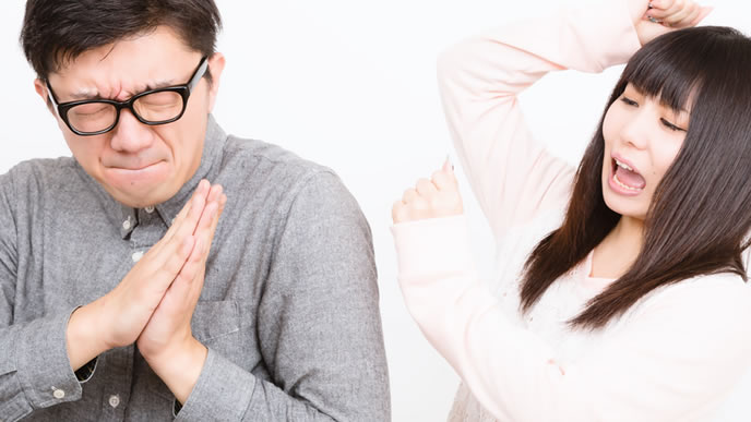 必死に謝る喧嘩中のカップル