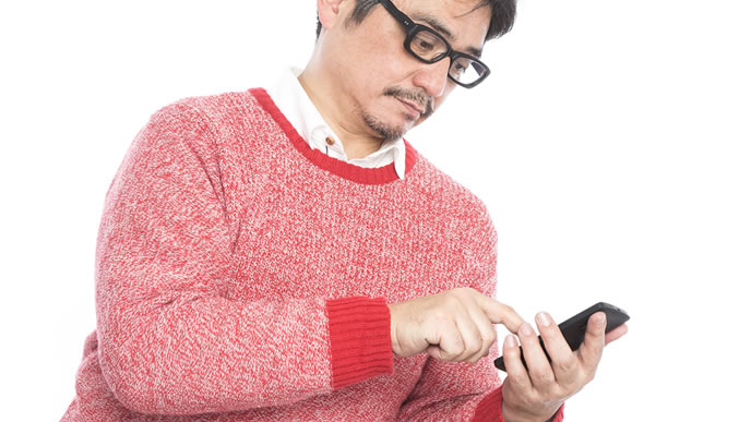転職サイトをスマホで見ている中年男性