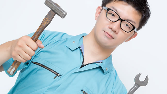 工場の器具を持ってポーズを取る男性