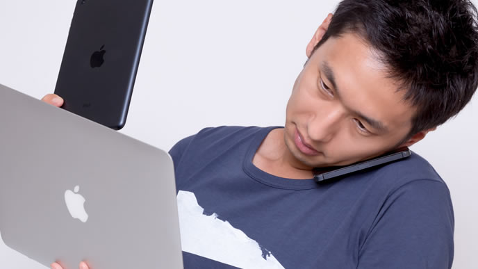 パソコンとスマホを同時に操るマルチタスクの男性