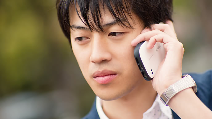 忙しい時間帯を外して電話連絡をする男性