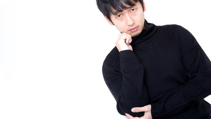 首元をガードしながら考えている男性