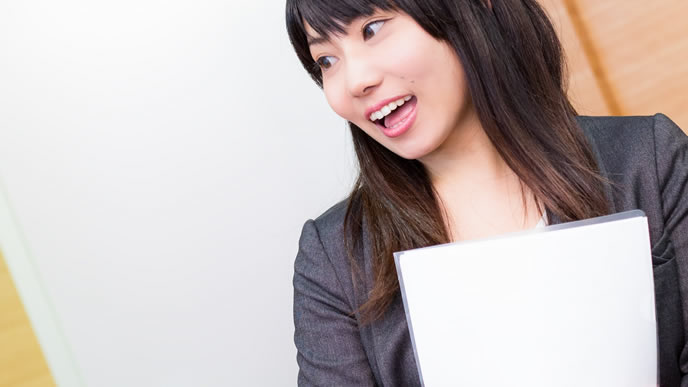 書類をクリアファイルに入れて持ち運ぶ女性