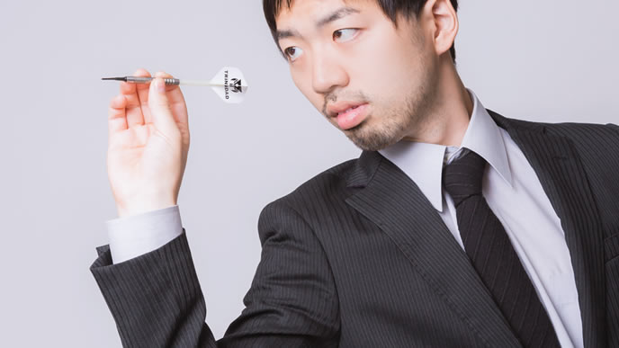 ダーツで自分の将来を決める男性