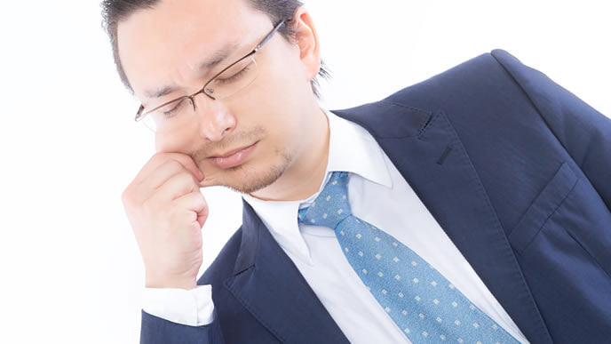 自分の性格を知るためにほっぺをつねる男性