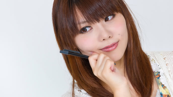 ペンを持って書き方を教わる女性