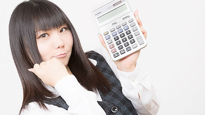 電卓で通勤時間を計算する女性