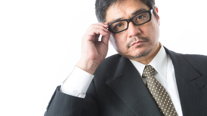 メガネを直して説教する学校教諭の男性