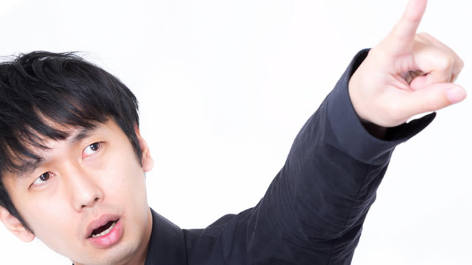 指差しをして真の目的を探ろうとする男性