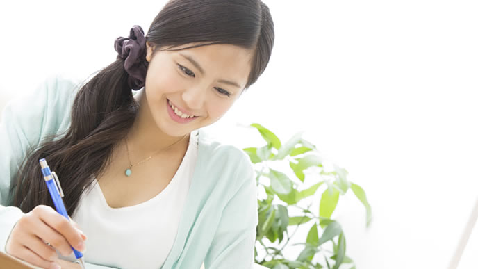 写真サイズの調整方法をメモる女性