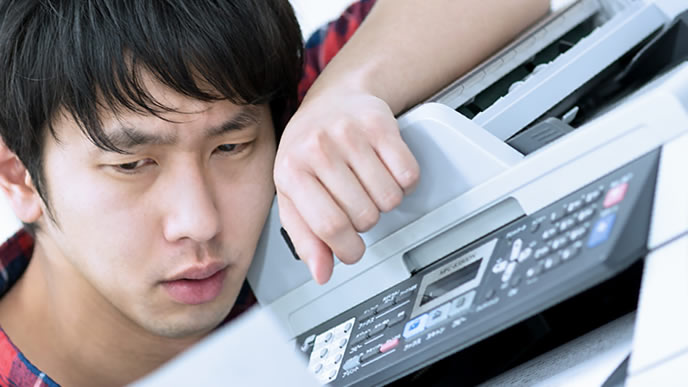 印刷したけど何か気に食わない表情の男性