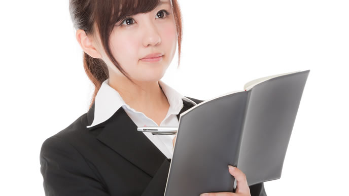 真剣にメモを取る真面目な女性