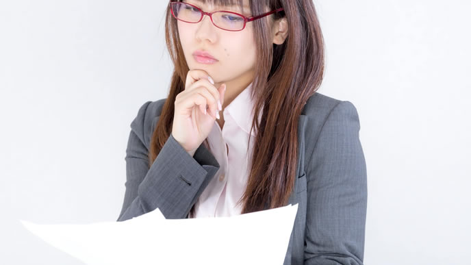 書類の情報を見つめる社員