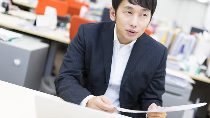 申し訳なさそうに履歴書を渡す男性