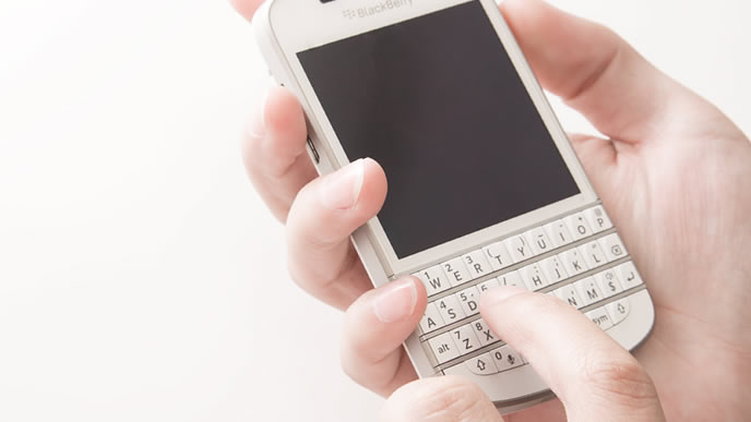 最終面接の結果が気になり携帯電話をいじる男性