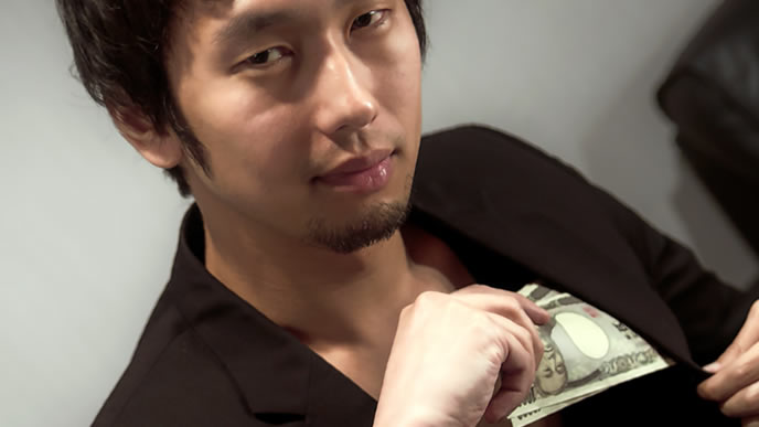 懐から大金を出す男性