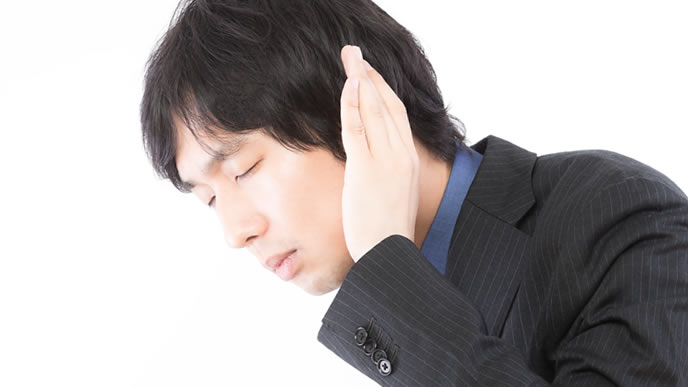 耳を澄まして聞き入る男性