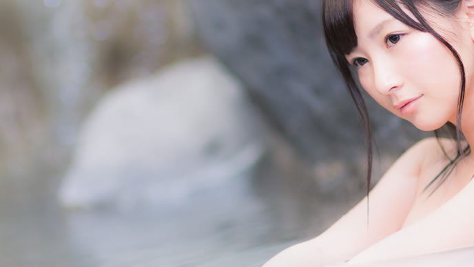 温泉に浸かりながらお金のことを考える女性
