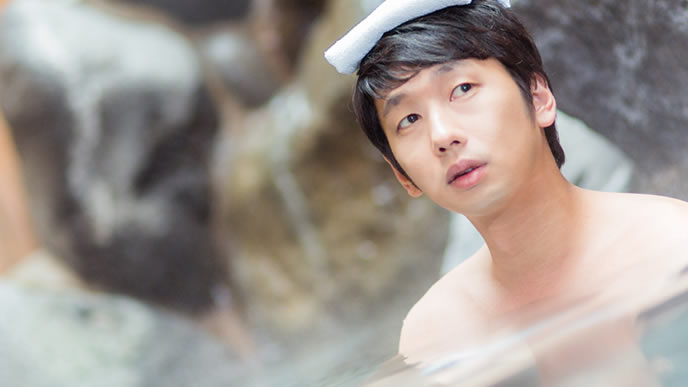 近くの温泉を利用してガス代を節約する男性