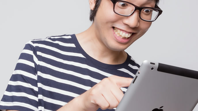 タブレットでニュースを見て情報収集する男性