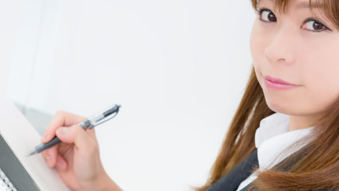 大事な事をメモする女性