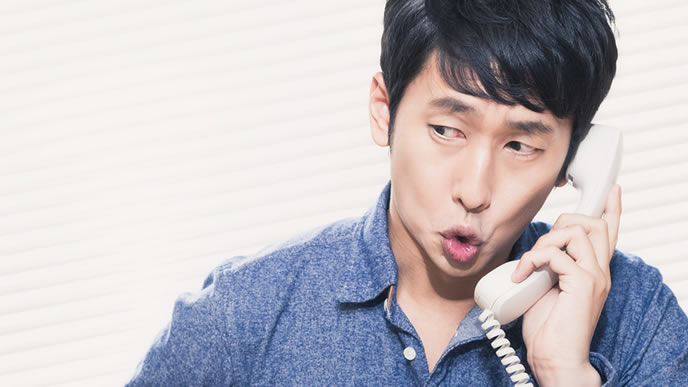 電話で辞退の連絡を入れる男性