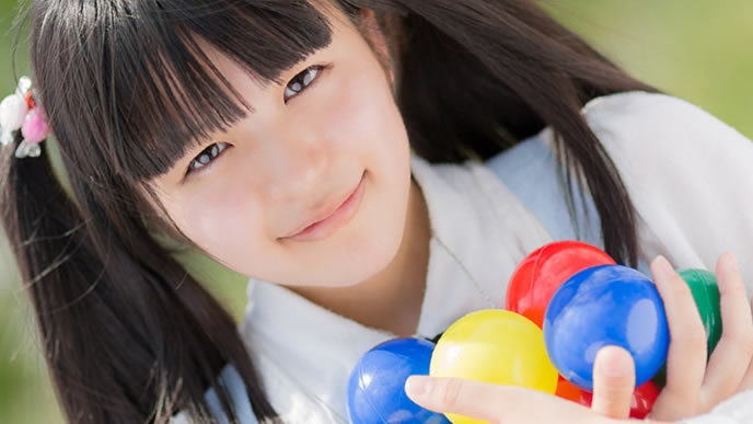 カラーボールと夢を両手で抱える女性